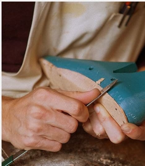 Hands finishing a sandal last by hand